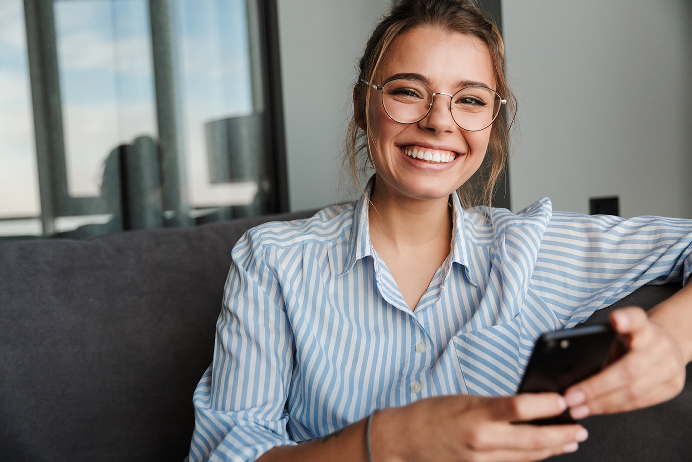 woman on her phone booking a dental exam at everlasting dental care