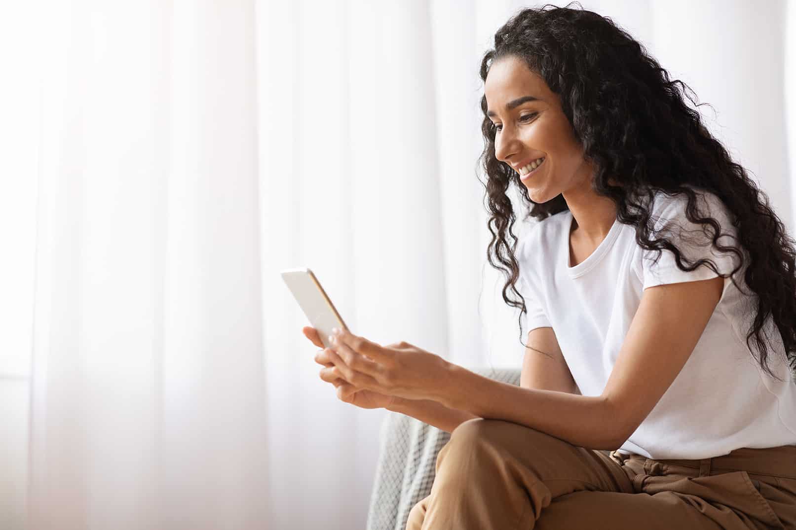 dental patient booking a dental implant restoration appointment on her phone at everlasting dental